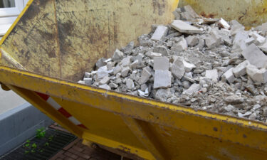 Yellow Skip Filled With Concrete Rubble And Demolition Waste