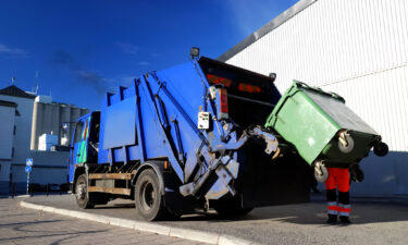 Waste Collection Truck Emptying A Commercial Bin On A Business Street