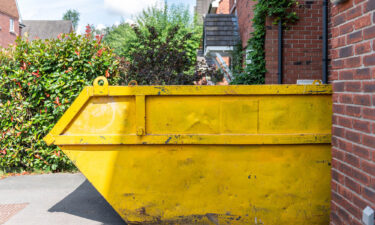 Yellow Skip Hire Container Placed On A Residential Driveway