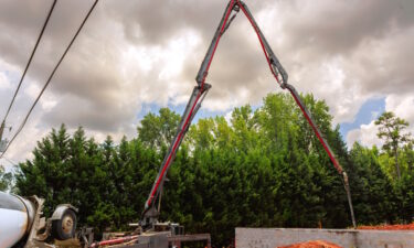 Concrete Pump Truck With Extended Boom Arm On A Construction Site
